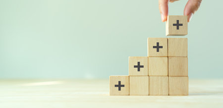 Positive things; added value, benefits, additional, personal development, growth mindset, positive thinking, opportunities, emerging market. Putting the cubes with plus sign to offer positive things.の写真素材