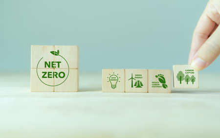 Net zero action concept. Save energy, green energy, reduce carbon footprint, carbon capture. Climate neutral long term strategy. Limit  global warming. Putting wooden cubes with green net zero iconの写真素材