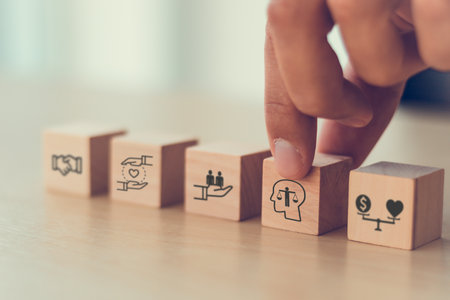 Business ethics concept. Ethics inside human mind. Business integrity and moral. Putting wooden cubes with ethics inside a head standing with other ethics icon. Company culture and sustainable successの写真素材