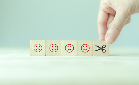 Reducing dissatisfied customers, managing complaints and claims. Bad ratings, bad reviews, customer dissatisfaction, angry. Wooden cube with negative, depression, sadness, mental problem, stress icon.の写真素材