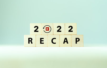 2022 Recap economy, business, financial concept. Business plan in 2023. RECAP words and 2022 on wooden cubes on smart grey background and copy space.の写真素材