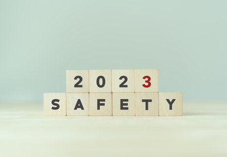 Work safety in 2023. Safety first, caution work hazards, danger surveillance, zero accident concept. Work safety planning and compliance. Wooden cubes inscripted 2023 and safety on smart background.の写真素材