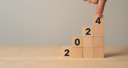 Business growth concept in 2024. Business goals and achievement. Sustainable development. Wooden cubes inscripted 2024 and growth icon on smart background. Positive indicators banner.の写真素材