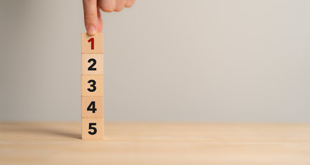 Task priority and management concept. The order of priority in any activity. Set work priority, arrange to do list. Wooden cube blocks with number first, second, third, fourth and fifth.の写真素材