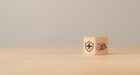 Health insurance concept. Healthcare, finance and medical service. Benefits of health insurance, medical expenses, providing financial security. Wood block with health insurance and money saving icon.の写真素材