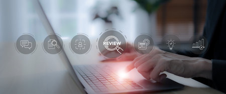 Business review concept. Working on laptop with review icons on virtual screen. Business and customer review for business strategic planning. End of the year business. Learn, improve and develop.の写真素材