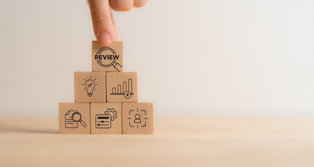 Business review concept. Wooden blocks with review text and review icons. Business and customer review for business strategic planning. End of the year business. Learn, improve and develop.の写真素材