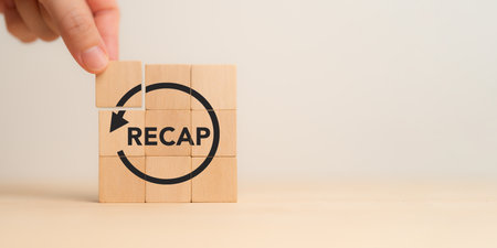 Recap economy, business, financial concept. Business planning.  RECAP text on wooden blocks and hand placing wooden blocks on minimal grey background and copy space.の写真素材