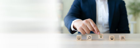 Design Thinking Process concept. Wooden blocks with icons; the key stages of the design thinking process, a solution-focused, problem-solving methodology used for innovation and strategic development.の写真素材