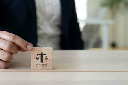 Business Ethics Concept. A person in business attire placing wooden blocks with an icon representing ethics; corporate responsibility, integrity and moral. The effective compliance and ethics culture.の写真素材