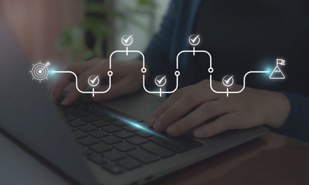 Digital workflow and goal tracking concept. Typing on a laptop keyboard with digital progress roadmap, icons of targets, check marks, and goal completion. Task management  and workflow optimization.の写真素材