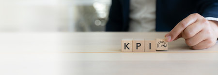 KPI and business performance indicator. Measuring productivity and strategic success. Wooden cube blocks with KPI letters and performance icon. Key performance indicators  and goal management.の写真素材