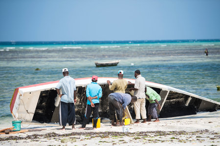 Zanzibar City, Tanzania-January 02,2019: Local fishermen are repairing their boats on the beach of Zanzibar Island.のeditorial素材