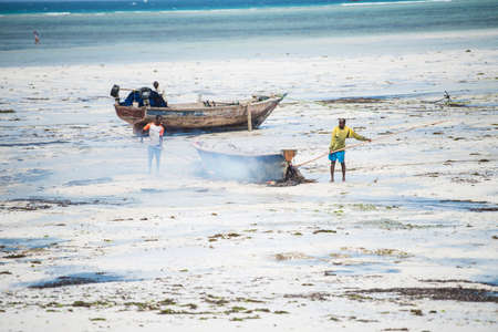 Zanzibar City, Tanzania-January 02,2019: Local fishermen are repairing their boats on the beach of Zanzibar Island.のeditorial素材
