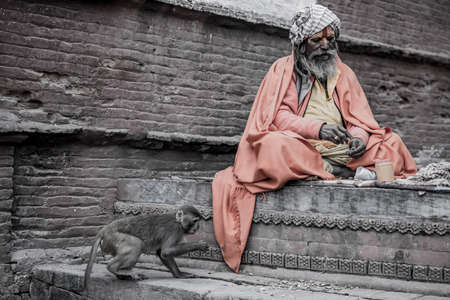 Kathmandu, Nepal- March 20,2022 : Sadhu-Indian Holymen sitting in the temple. In Hinduism, Sadhu is a common term for a mystic, an ascetic, practitioner of yoga.のeditorial素材