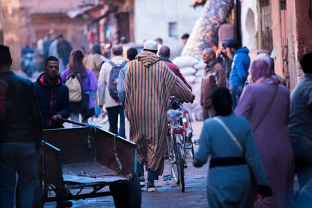 Marrakesh, Morocco -March 28, 2022: A typical street in the ancient Medina district of Marrakech. Photo contains local people doing various activities.のeditorial素材