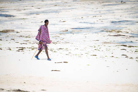 Zanzibar, Tanzania - January 02,2022: Masai warriors dressed in traditional clothes on sand beach of Zanzibar island.のeditorial素材