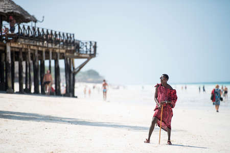 Zanzibar, Tanzania - January 02,2022: Masai warriors dressed in traditional clothes on sand beach of Zanzibar island.のeditorial素材