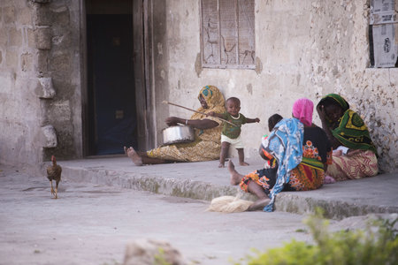 Zanzibar, Tanzania - January 05,2022: Street view of the usual daily life of local people all ages taking place along the road on the Zanzibar Island in Tanzania.のeditorial素材
