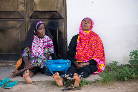 Zanzibar, Tanzania - January 05,2022: Street view of the usual daily life of local people all ages taking place along the road on the Zanzibar Island in Tanzania.のeditorial素材