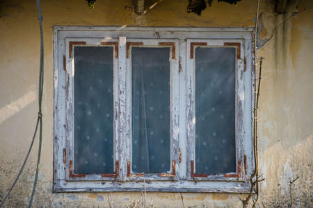 Sunja, Croatia, April 20,2021 : Rustic style aged window at rural home wall.