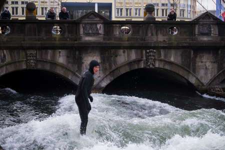 Munich, Germany - December 20, 2021: Surfer in the city river, Munich is famous for people surfing...