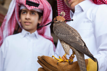 Doha ,Qatar-April 15,2022 : Qatari children with a falcon in the area Souq Waqif in Doha.のeditorial素材