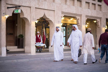 Doha,Qatar - April 15,2022 : Qatari locals in traditional attire hang out in old bazaar market Souk Waqif.のeditorial素材