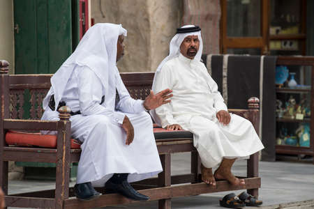 Doha,Qatar - April 15,2022 : Qatari locals in traditional attire hang out in old bazaar market Souk Waqif.のeditorial素材