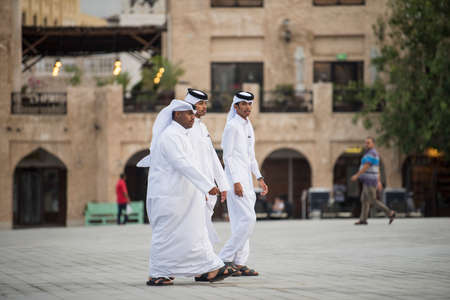 Doha,Qatar - April 15,2022 : Qatari locals in traditional attire hang out in old bazaar market Souk Waqif.のeditorial素材