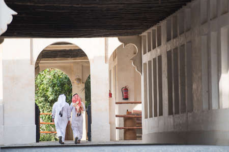 Doha,Qatar - April 15,2022 : Qatari locals in traditional attire hang out in old bazaar market Souk Waqif.のeditorial素材