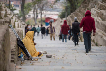Kathmandu, Nepal- April 20,2019 : The cripple begs on the street of Pashupatinath Temple in...