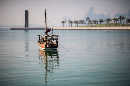 Doha,Qatar- April 24,2022 :  Traditional dhow boats with the futuristic skyline of Doha in the...