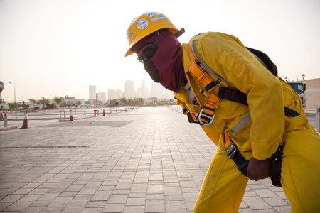 Firefighter in yellow uniform and helmet on the ground in the city.の写真素材