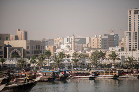 Doha,Qatar- April 24,2022 Traditional boats called Dhows are anchored in the port near the Museum of...