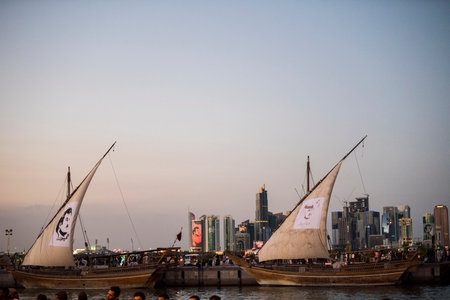 Doha,Qatar- April 24,2022 Traditional boats called Dhows are anchored in the port near the Museum of Islamic Art Park.のeditorial素材