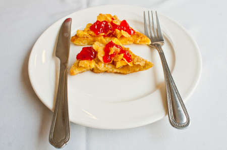 Bread topped with honey and cereal with strawberry jam
