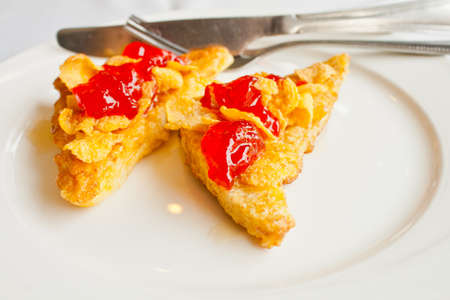 Bread topped with honey and cereal with strawberry jamの写真素材