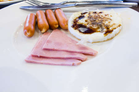 American breakfast sausage and ham on a white dish