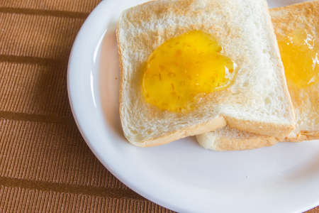 bread with jam on white dishの写真素材