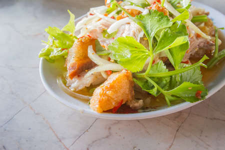 Spicy salad fish in a dish on tableの写真素材