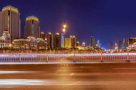 Urban road with commercial buildings in Tianjin at nightの写真素材