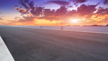 Asphalt road bend and fire burning cloudの写真素材