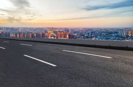 Asphalt road carriageway and city buildings landscapeの写真素材