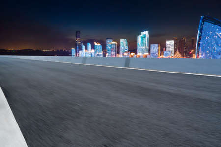Road ahead and financial district buildings at night