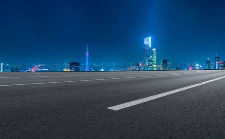 Night view of asphalt road and buildings in financial districtの写真素材