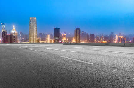 Night view of highway lanes and financial district buildings