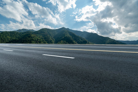 Asphalt road and mountain with blue sky background, panoramic viewの写真素材