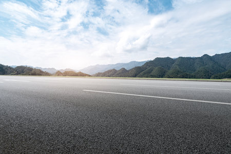 Asphalt road skyline among mountainsの写真素材
