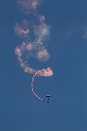 Parachuting show in the sky with colored smokeの写真素材